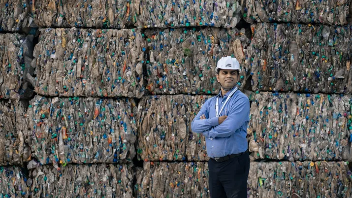 Srichakra executive in front of plastic bottles to be recycled - Hyderabad