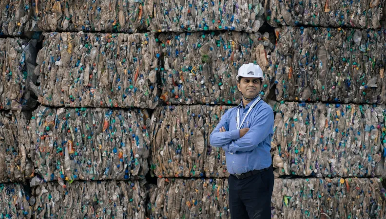 Srichakra executive in front of plastic bottles to be recycled - Hyderabad